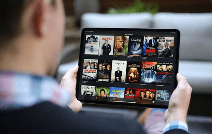 couple sitting on a couch watching Disney+ Hotstar on a television